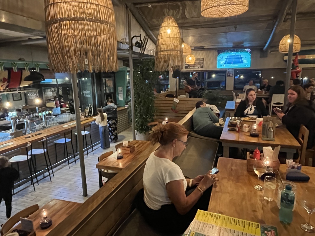 Chanteur guitariste au fond sur l’estrade