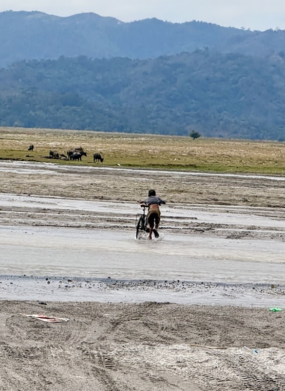 il passe a pied un gué avec son vélo