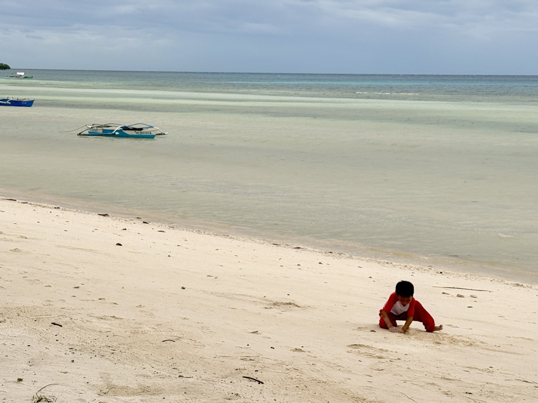 Pas ennuyé par les touristes et leurs serviettes pour faire des châteaux de sable ce petit Philippins.